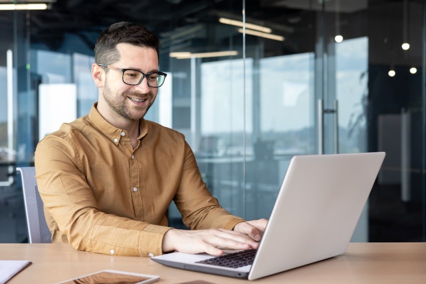 Junger-Mann-mit-Hemd-am-Laptop